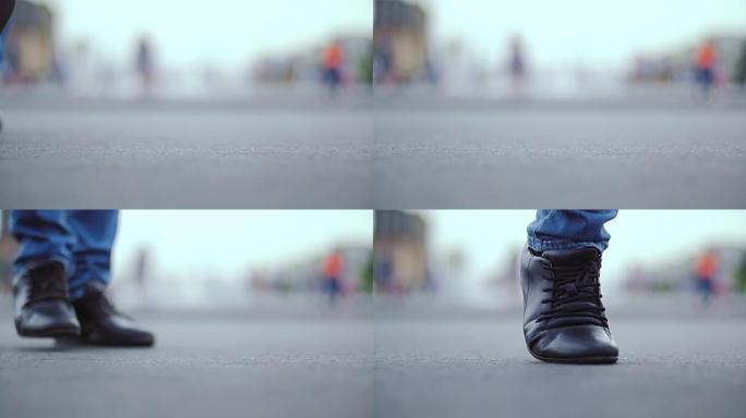 穿着黑色靴子和牛仔裤的男人的腿相对于相机斜向移动。
