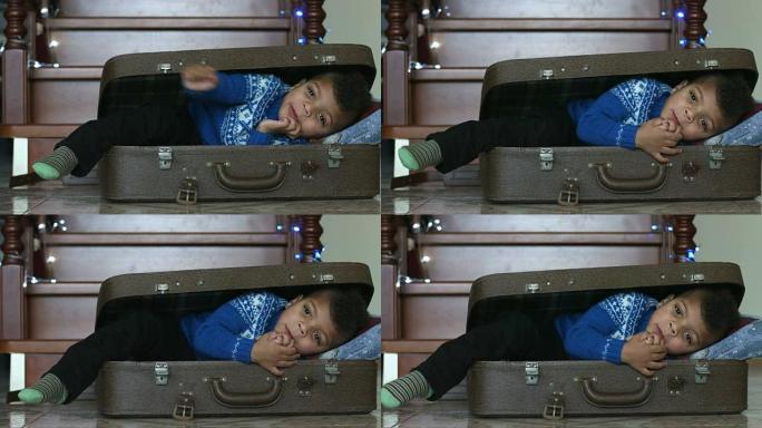 微笑的孩子躺在手提箱里。