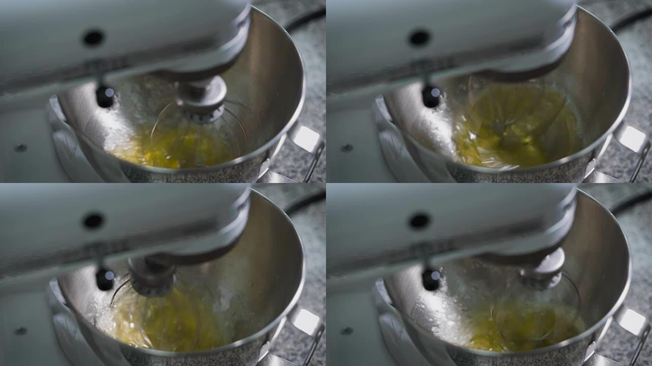 搅拌机搅打的蛋清，用于在面包店厨房的金属碗中制作奶油。糖果制备的专业设备。花冠快速转动