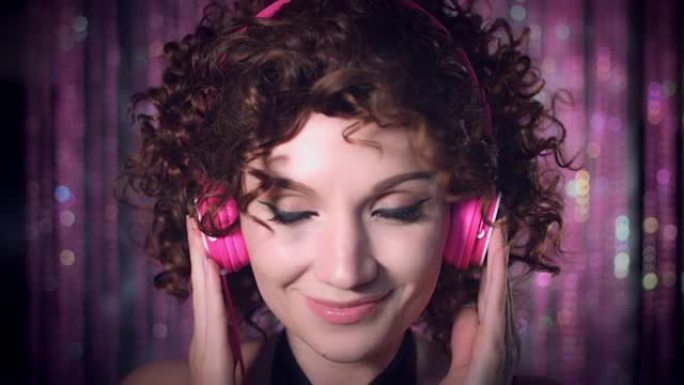 4k迪斯科卷发性感女人戴上粉色耳机