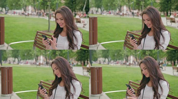 一个美丽的黑发女人在户外使用手机