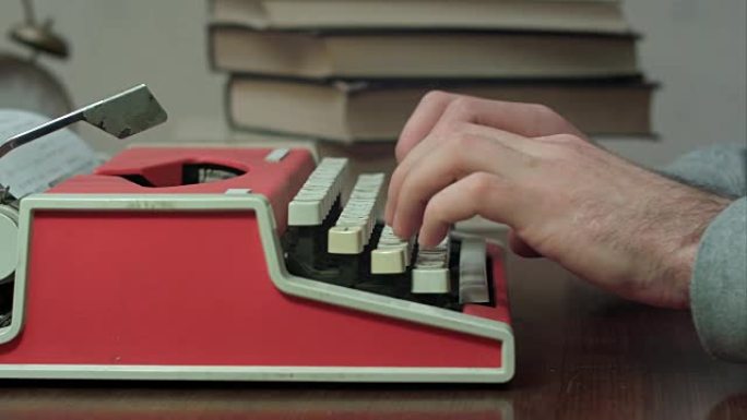 男人的手在红色打字机上打字