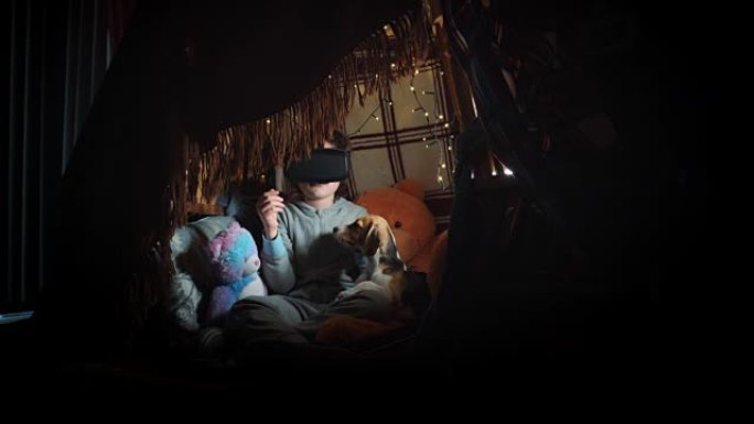 用VR耳机和他的小狗在毯子下拍摄的4k照片