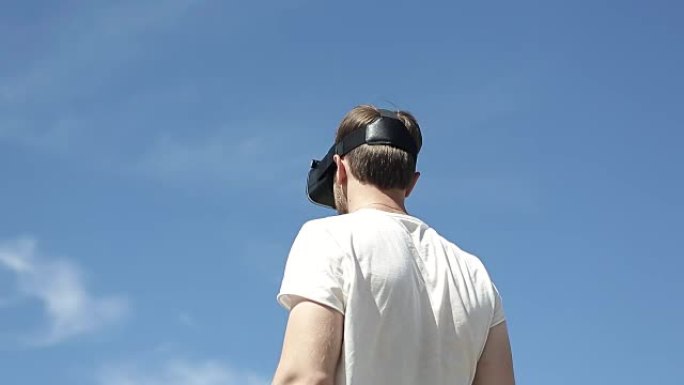 男子在天空的背面使用虚拟现实眼镜