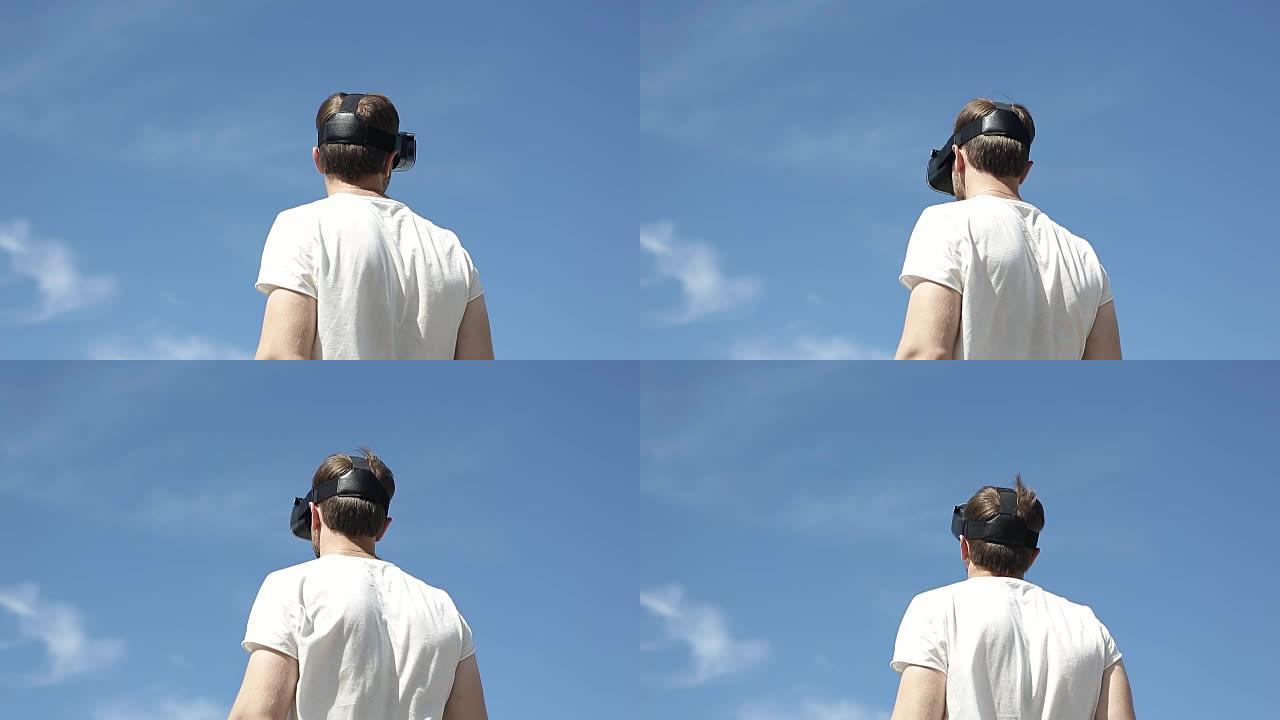 男子在天空的背面使用虚拟现实眼镜