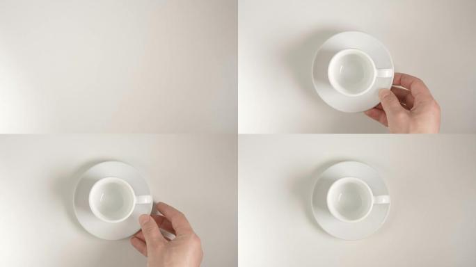 俯视图: 人手将白色咖啡杯放在白色桌子上