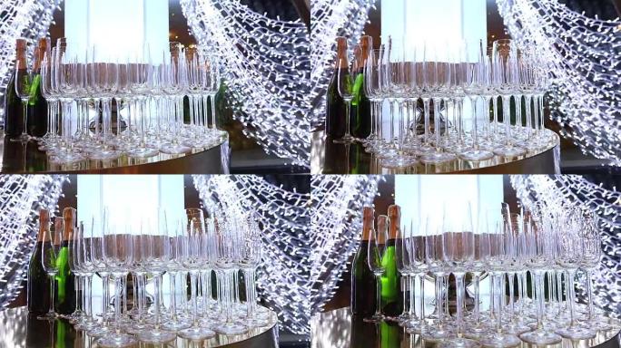 自助餐桌上的玻璃杯，一瓶香槟，餐厅设计，室内，室内，相机沿着桌子平稳移动，桌上一排排酒杯，浅景深