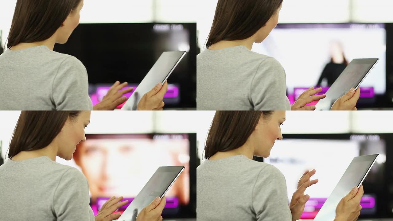 女人在电视前使用平板电脑
