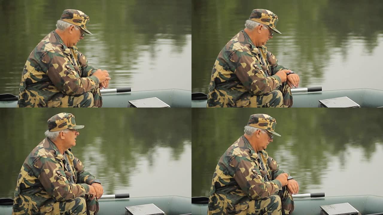 在湖上触摸智能手表的人。充气船上有钓鱼竿的渔夫