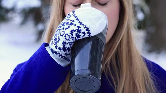 女人在冬天喝热水杯热葡萄酒