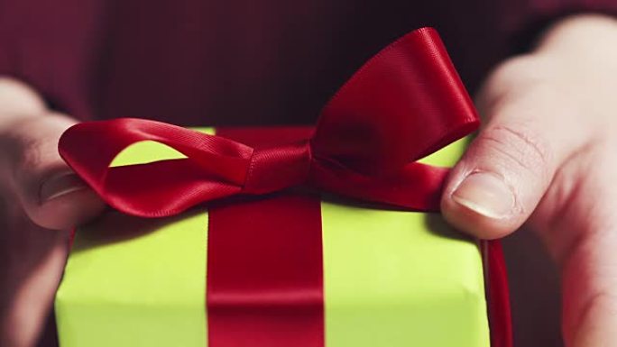 女少女展示带红丝带和蝴蝶结的绿色礼品盒