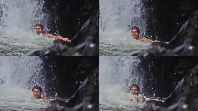 帅哥在热带丛林瀑布的溪水下放松。慢动作。1920x1080，高清