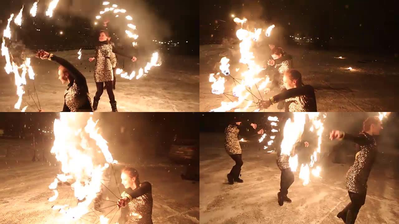 令人惊叹的部落火灾表演在冬天的夜晚在飘雪下跳舞。舞蹈团在下雪的天气用火炬灯和烟火表演