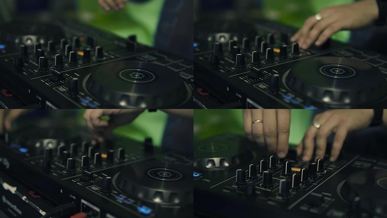 DJ调整DJ控制面板上的轨道控件。