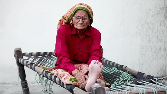 坐在Charpai上的老年妇女