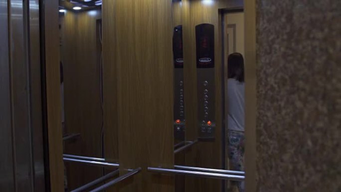 电梯门打开，一个女孩从里面出来。