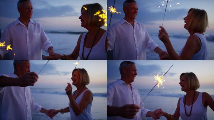 Mature Caucasian couple fun with sparklers on beac