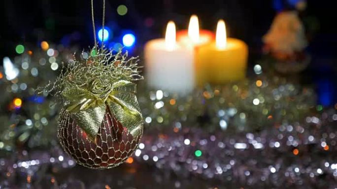 一个漂亮的红色大球。新年和圣诞装饰品。燃烧蜡烛。闪光花环。背景模糊。