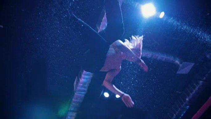 年轻人杂技演员在蹦床上跳跃 -- 慢动作，底部视图