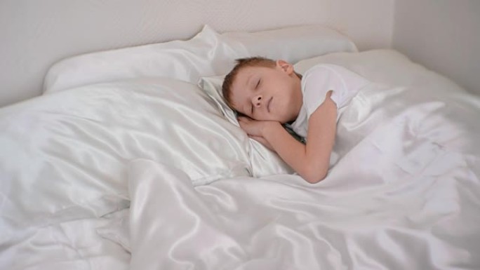 一个七岁的男孩安静地睡在房间的床上，双手放在头下。