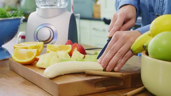 女人的手在厨房的砧板上切各种水果