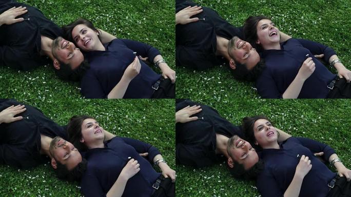 甜蜜的情侣躺在草坪上聊天
