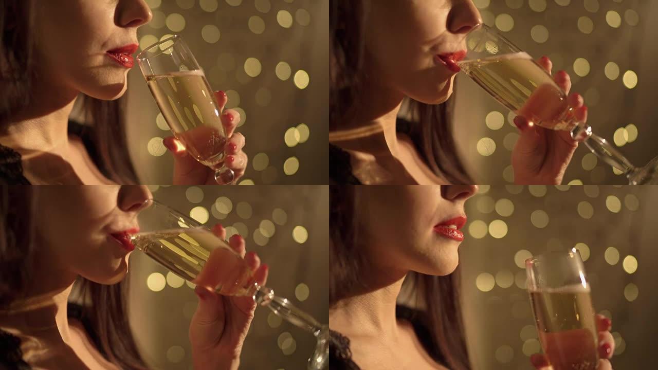 美丽的女人在圣诞节花环灯下喝香槟