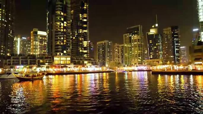 杜拜市中心晚上倒映在水中。城市在夜晚，市中心的全景场景映在水中，迪拜。杜拜市中心夜晚在水中倒影，新城