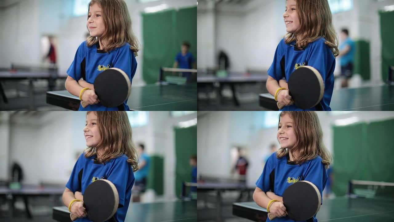 一个小女孩拿着乒乓球拍的肖像