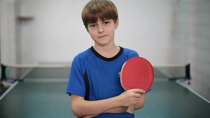 一个小男孩拿着乒乓球拍的肖像