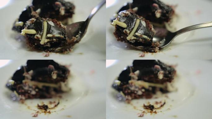 用勺子将一块巧克力蛋糕打碎在盘子上