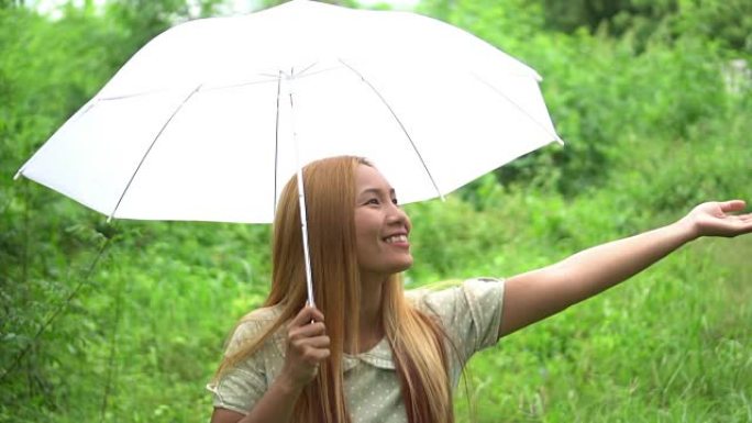 女人在雨下走路手拿着白伞