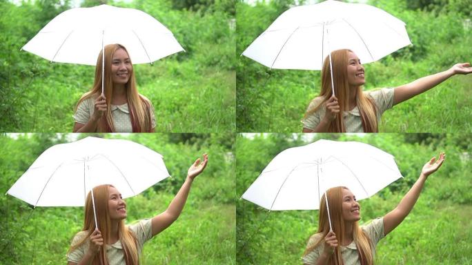 女人在雨下走路手拿着白伞
