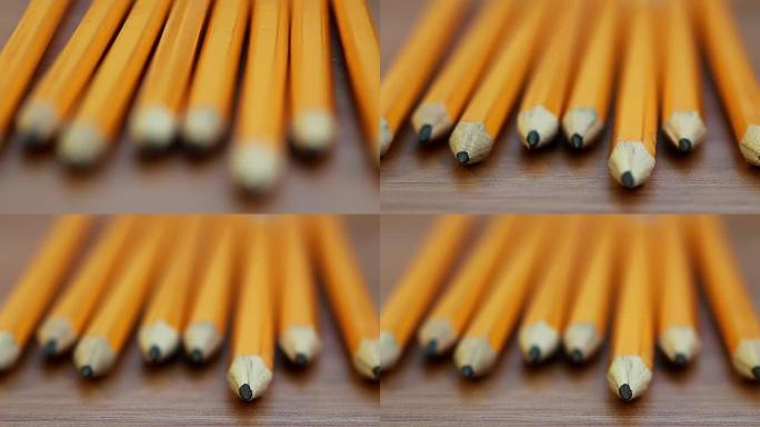 桌上一排铅笔的拉焦镜头相机焦点从长焦距转移到短焦距