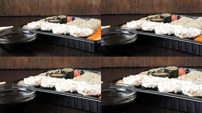 相机变焦。大型寿司套装，配有各种寿司卷，以及时尚的黑色木制背景上的maki、nigiri、gunka