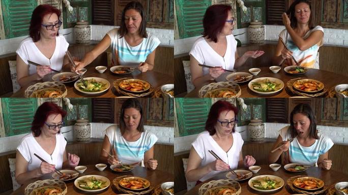 妇女坐在日本餐馆里，用筷子说话和吃饭