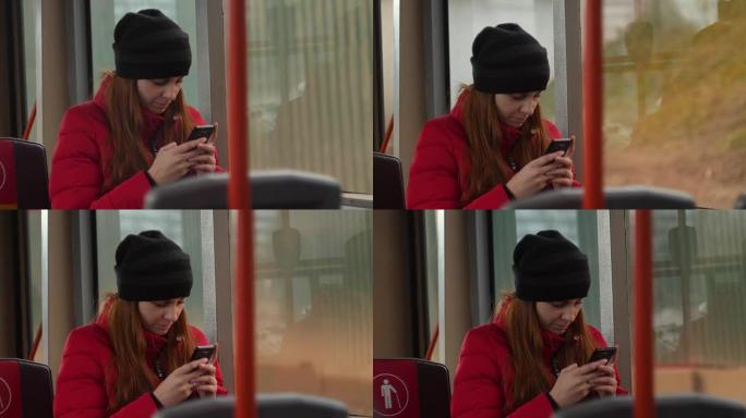 悲伤的年轻女子在晚上乘公共汽车时用手机打字。公交车车窗内散焦的城市交通慢动作4k镜头
