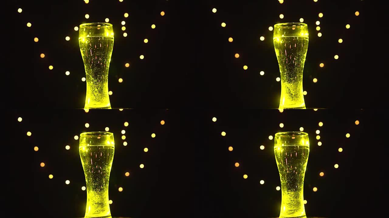 黄光中的一杯水在旋转。黄色鸡尾酒。酒吧概念