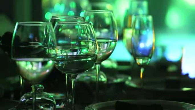 餐厅桌子上的玻璃眼镜，舞台照明，背景，黑暗，浅景深，特写
