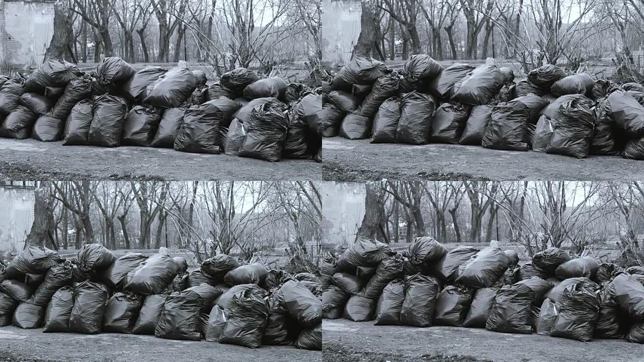 城市里堆积的黑色垃圾袋的特写镜头。黑白相间。