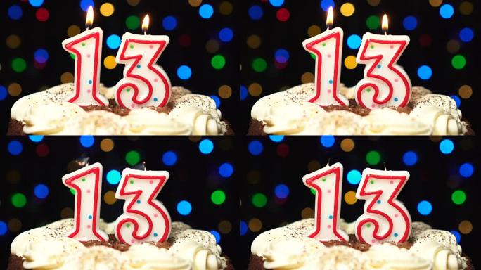 蛋糕上的第13号-十三岁生日蜡烛燃烧-最后吹灭。彩色模糊背景