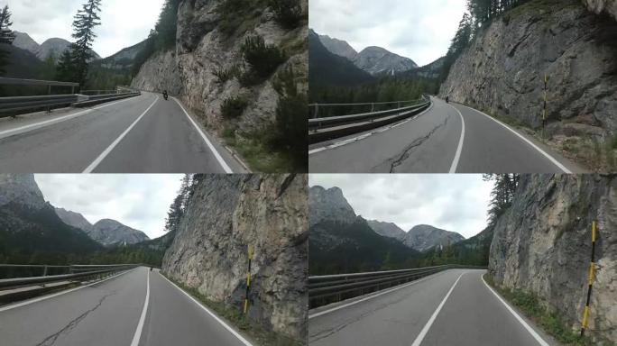 骑摩托车的人骑在意大利美丽的风景山路上。第一人称视角