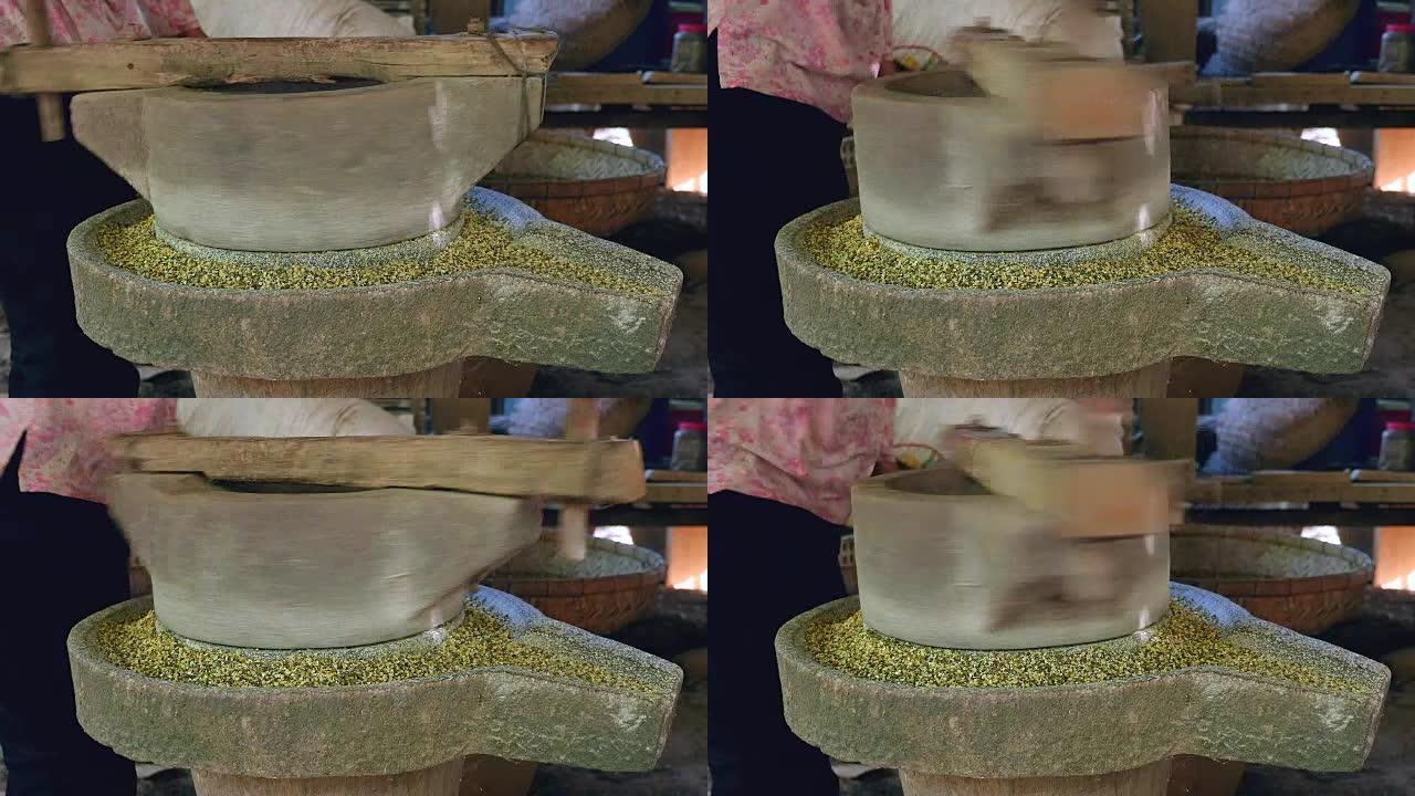一个女人用手翻磨石磨绿豆的特写镜头