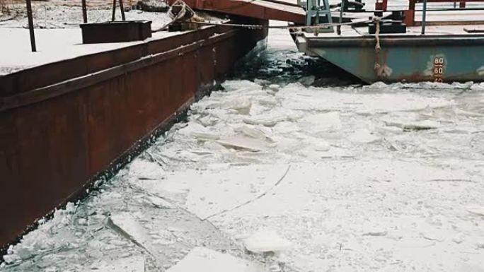 寒冷的冬日，生锈的金属路堤在冰冻的湖中被雪覆盖