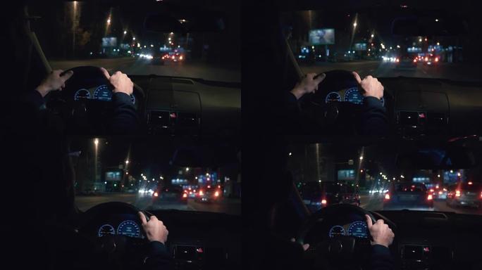 把手放在方向盘上。司机晚上开着一辆黑色汽车。