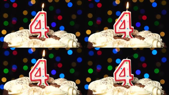 蛋糕上的4号 -- 四根生日蜡烛燃烧 -- 最后吹灭。彩色模糊背景