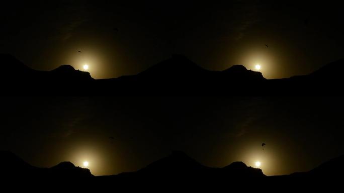 滑翔伞在山上日落时练习滑翔伞运动