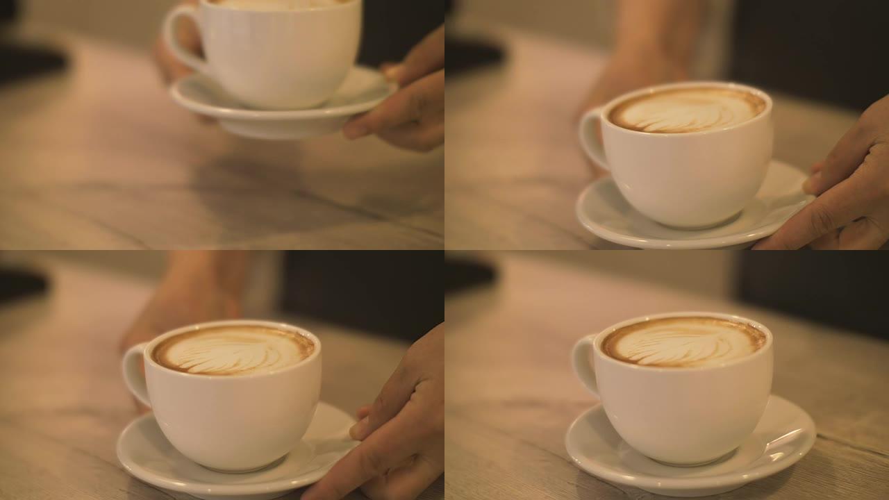 咖啡师将准备好的咖啡卡布奇诺杯放在咖啡馆的桌子上特写