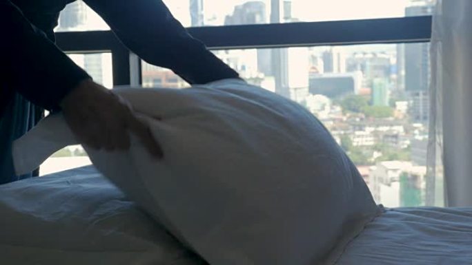 女人在慢动作中俯瞰现代城市的床上蓬松枕头