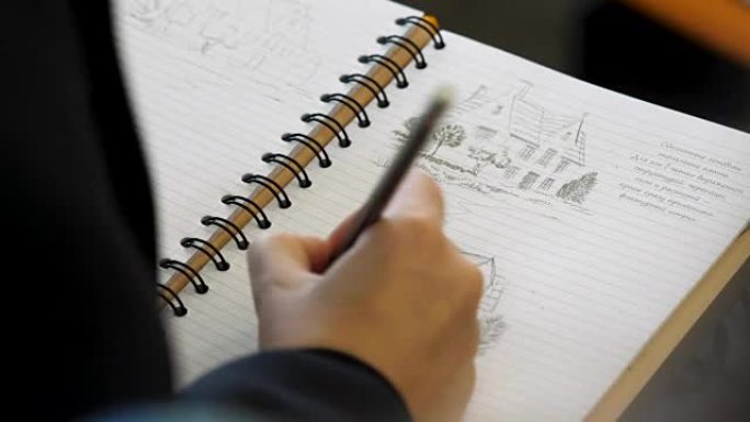 手握铅笔在笔记本上写字或画画。成人用软尖铅笔着色。女手绘图铅笔在笔记本特写